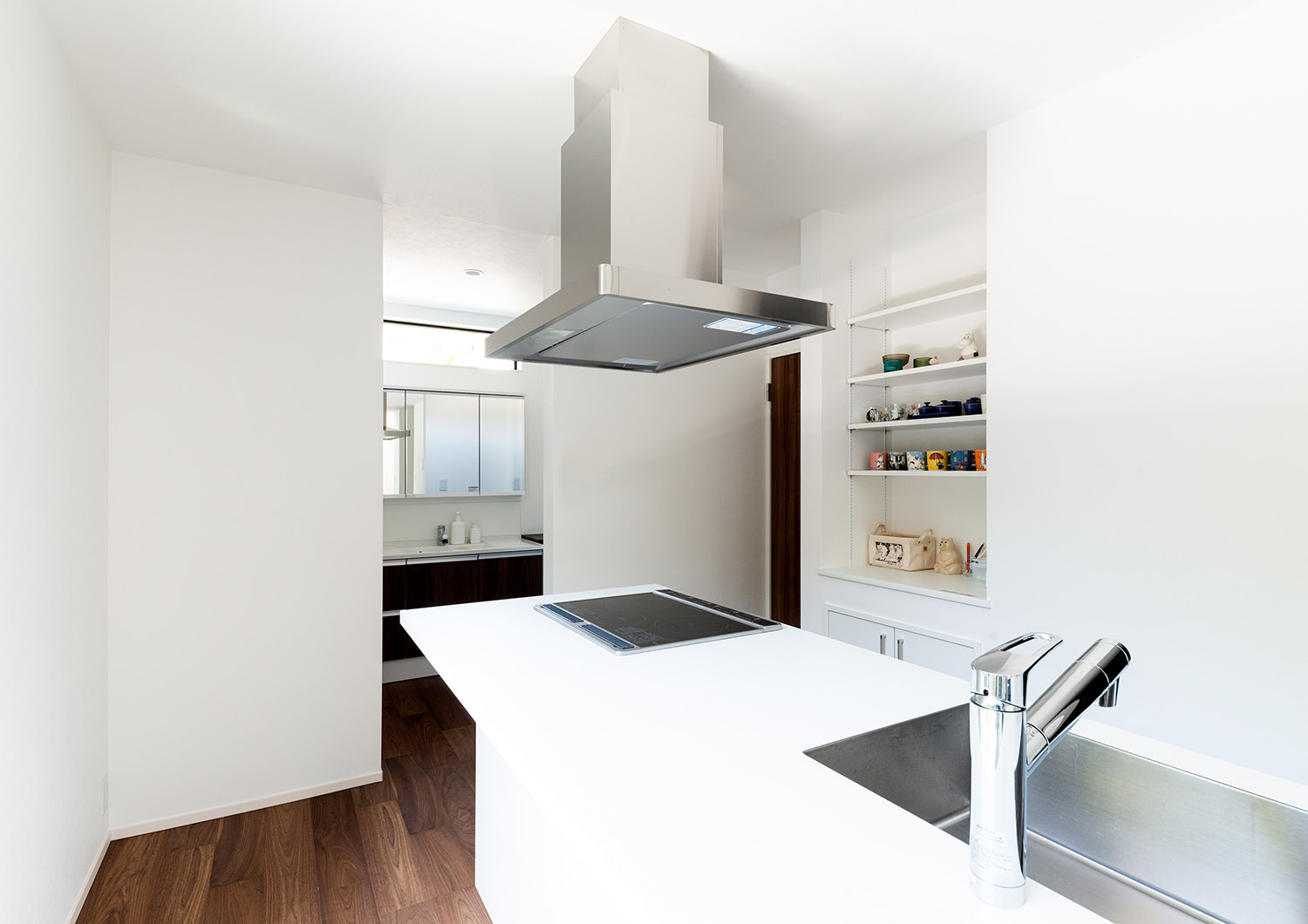背面のカップボードまで白で統一された清潔感のあるIHキッチン・デザイン住宅