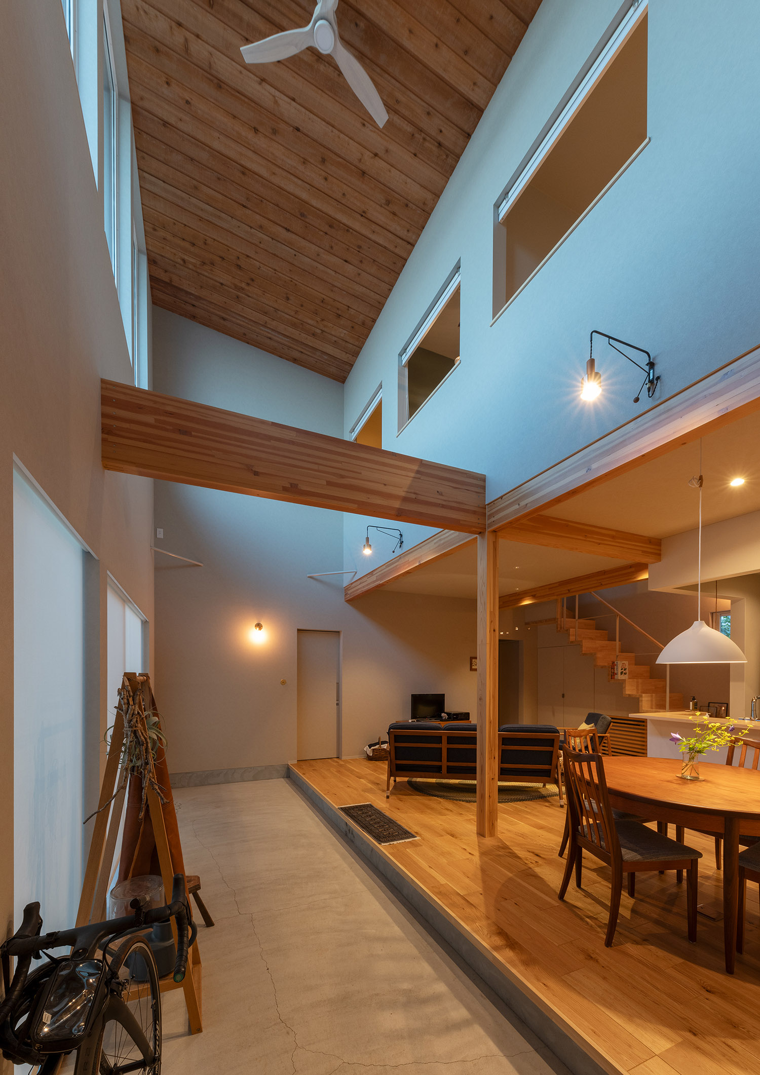 壁にシンプルなペンダントライトを取り付けた木目の天井の吹き抜け・デザイン住宅