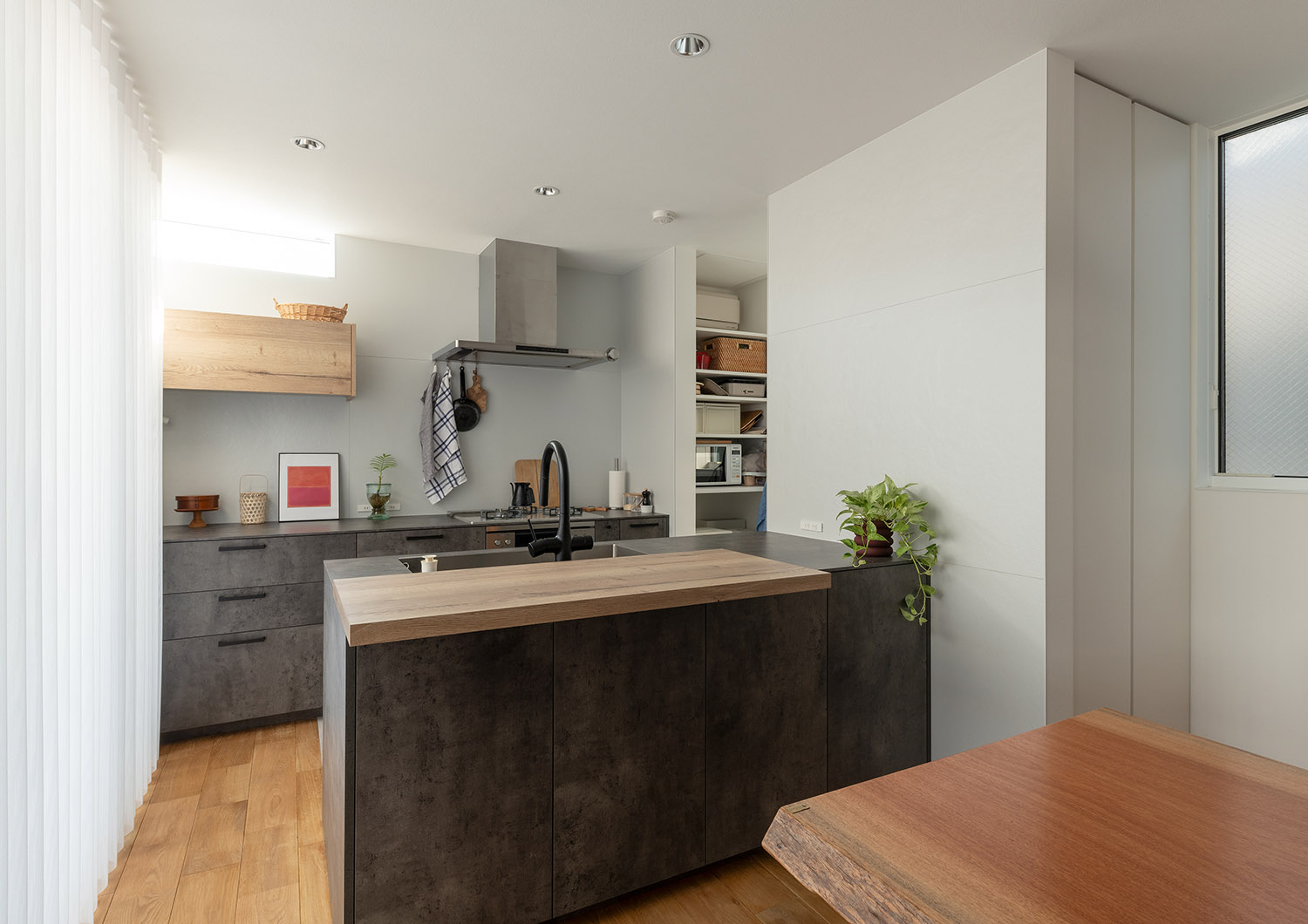 木のカウンターを取り付けたアイアン風のⅡ型キッチン・デザイン住宅