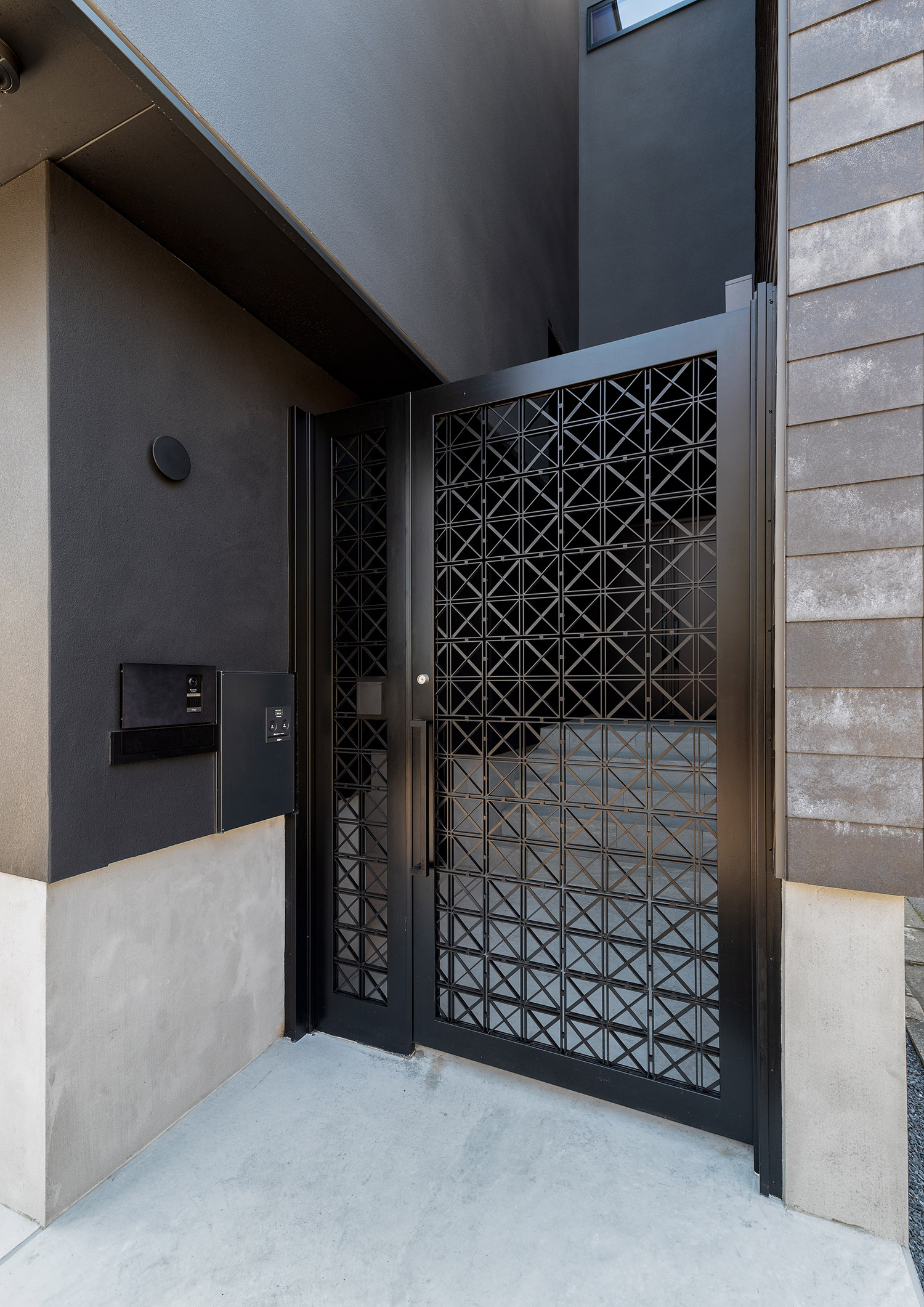おしゃれな黒い門扉がある高級感のある玄関ポーチ・デザイン住宅