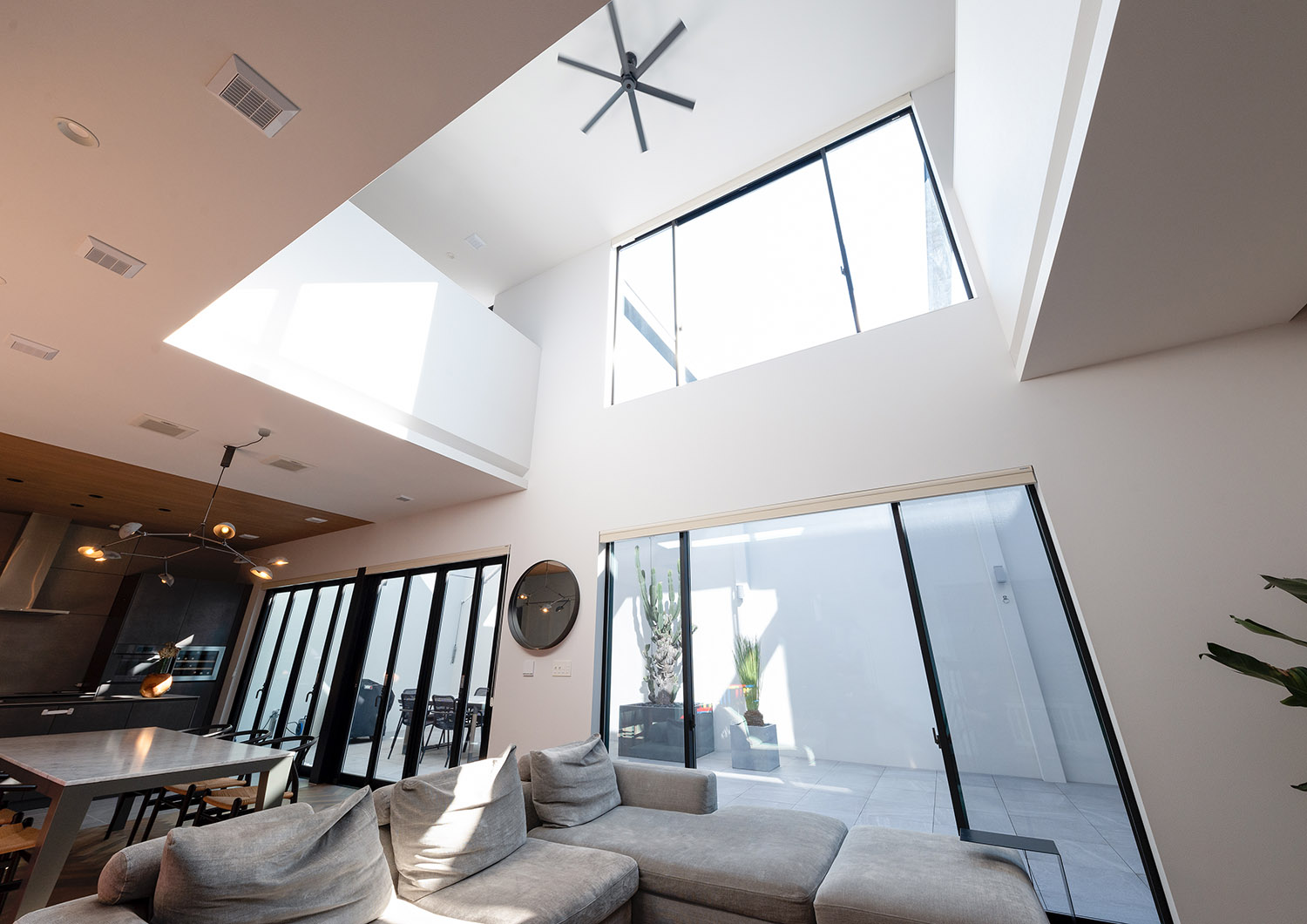天井にシーリングファンが取り付けられた吹き抜けの開放感があるLDK・デザイン住宅