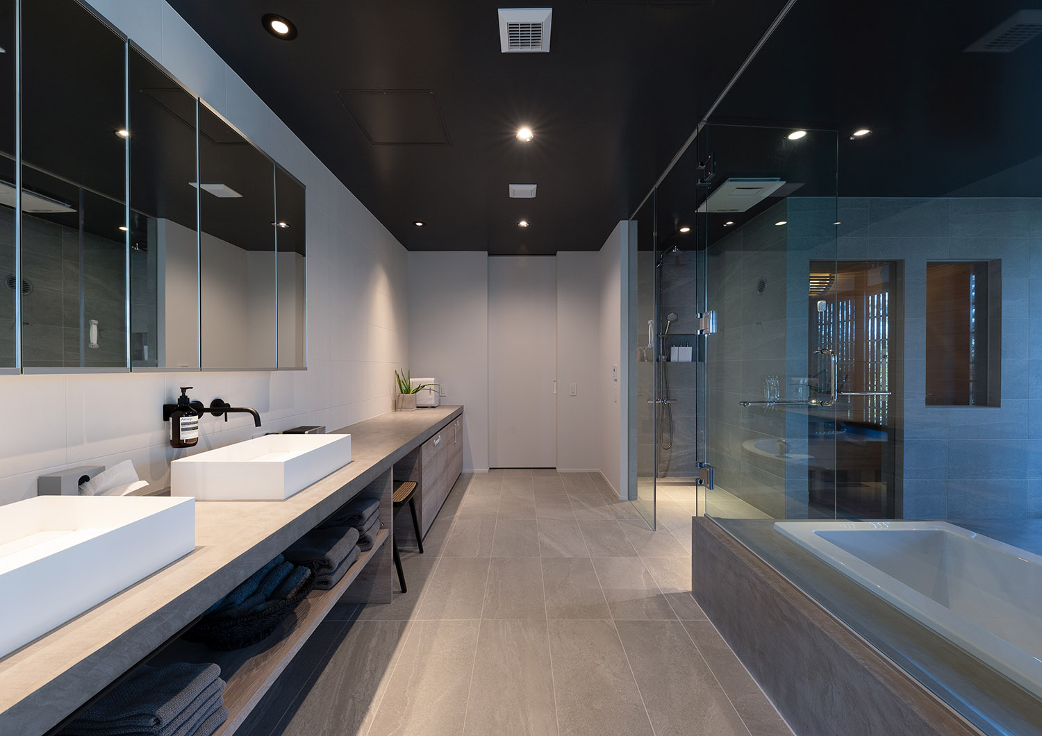 ダブルボウルの洗面台とガラス扉付きの浴室があるホテルライクな水回り・デザイン住宅
