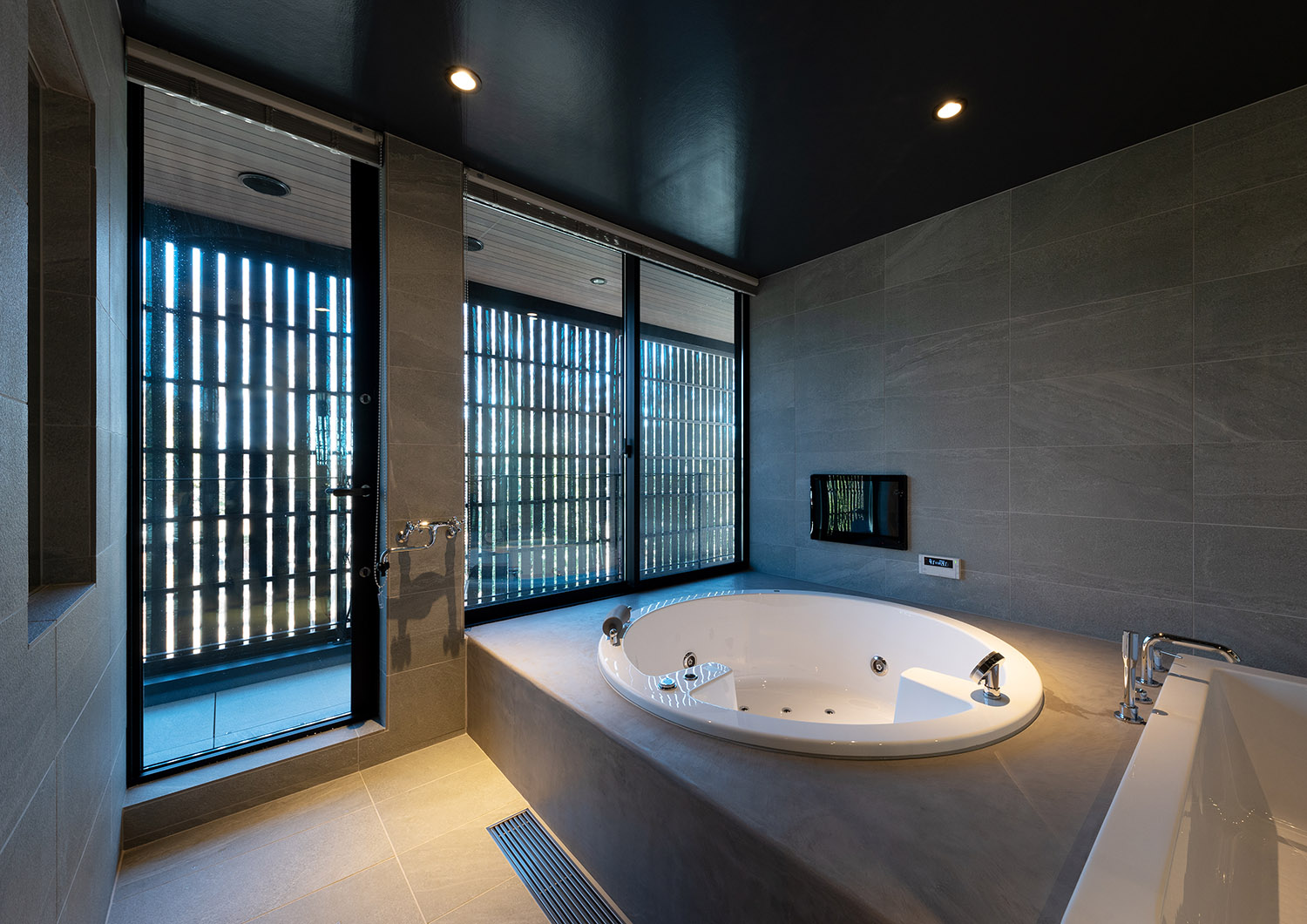 丸いバスタブで、外気浴が出来るスペースがある高級感があるホテルライクな浴室・デザイン住宅
