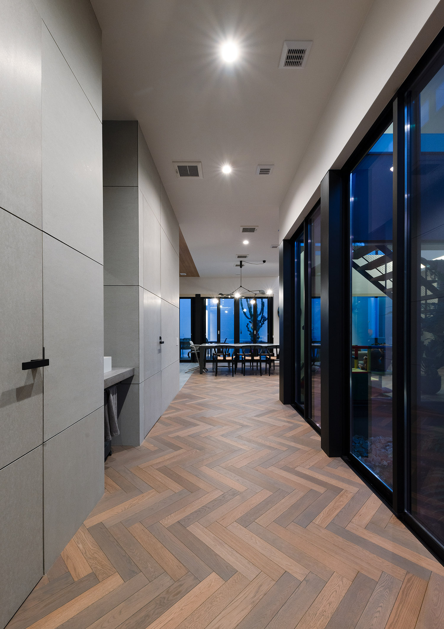 リビングと繋がるヘリンボーン床の開放的な廊下・デザイン住宅
