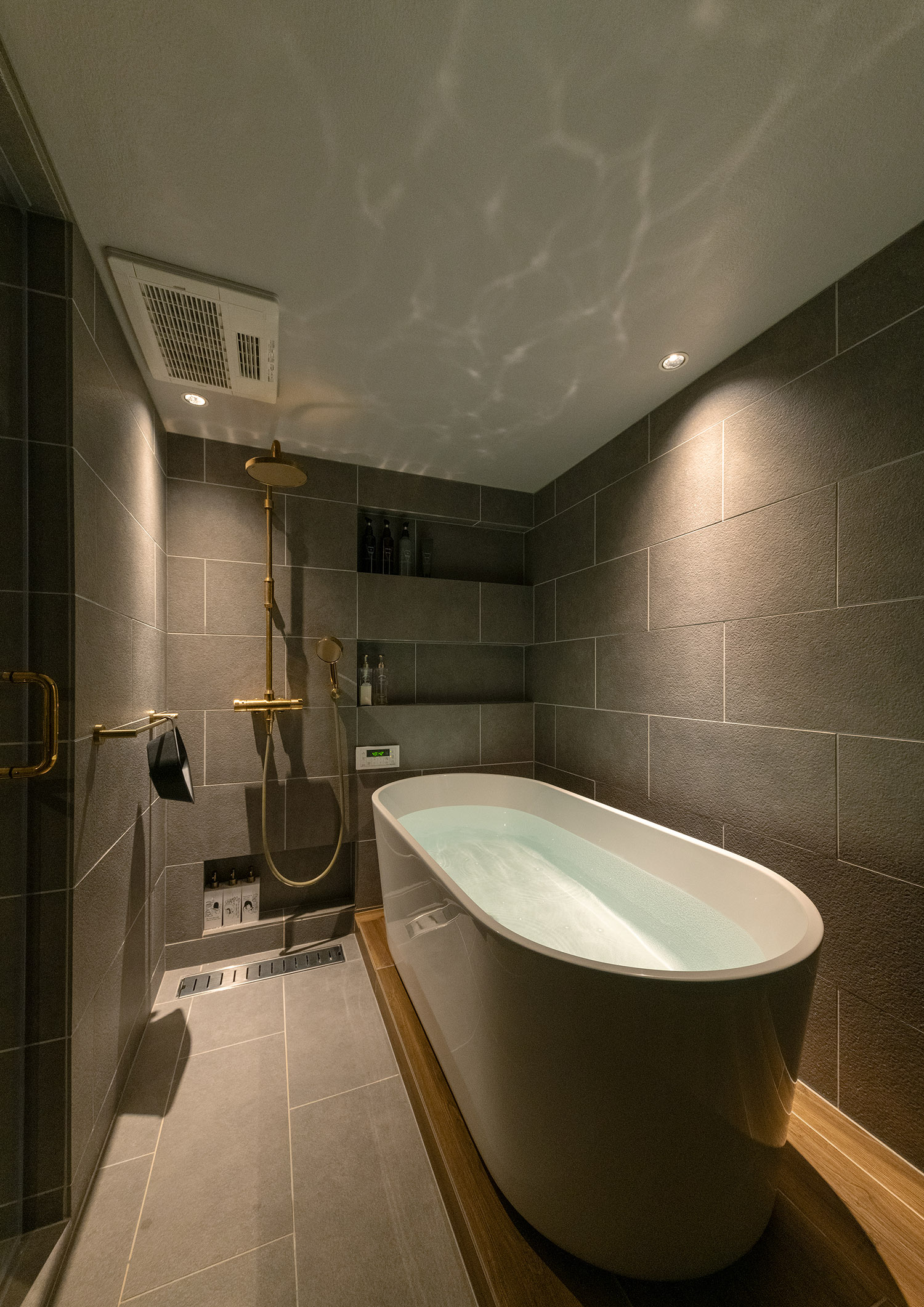 タイル壁で丸い浴槽があるホテルライクで高級感のある在来浴室