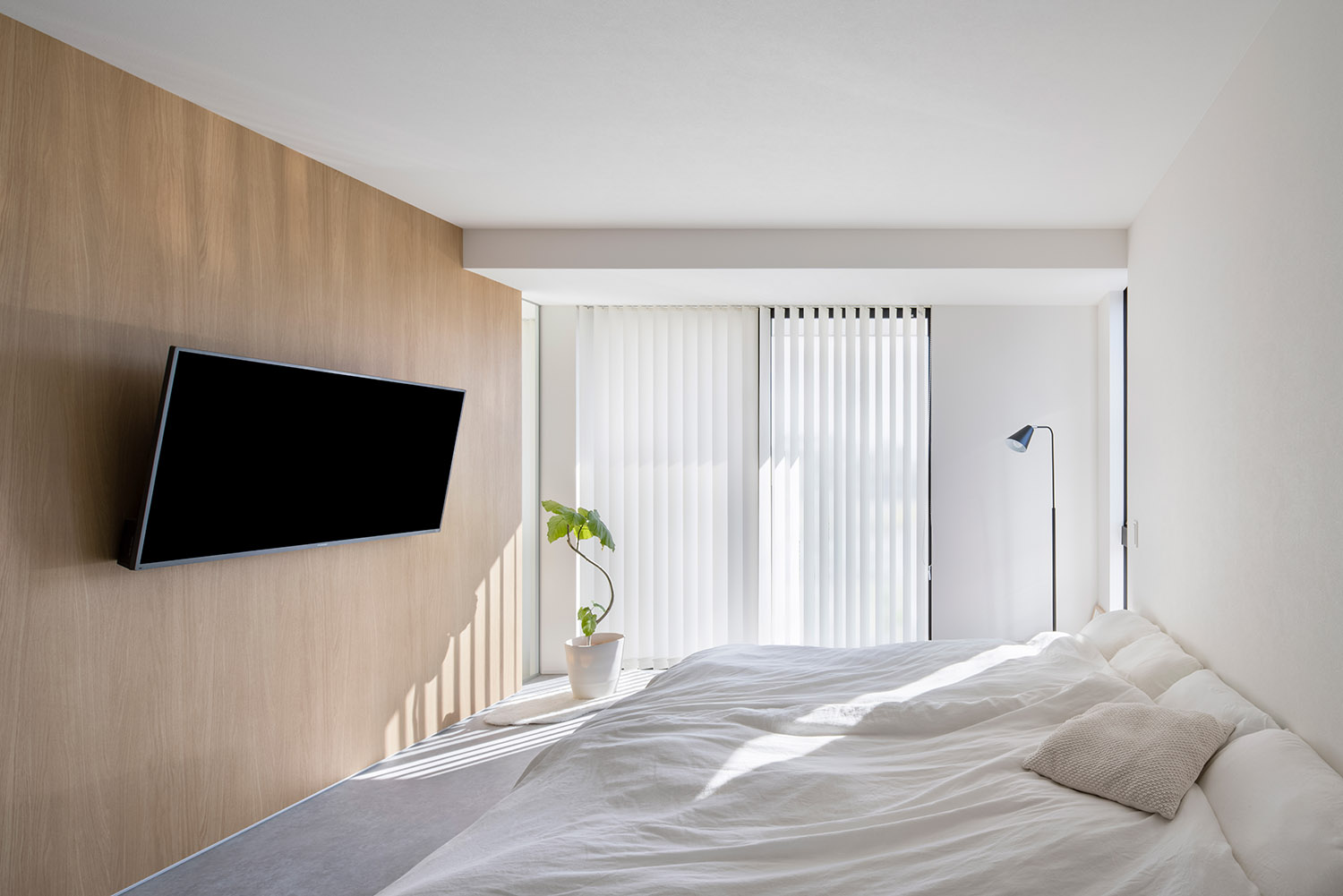 壁付けテレビがあるシンプルでホテルライクな寝室・デザイン住宅